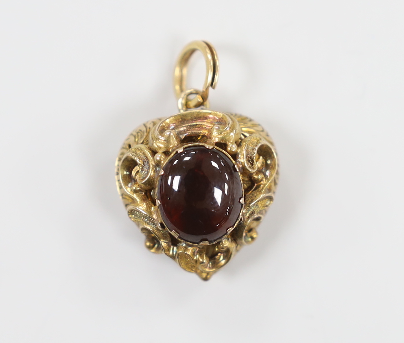 A Victorian yellow metal and cabochon garnet set heart shaped pendant, with glazed back, 21mm, gross weight 6 grams.